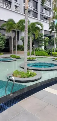 a swimming pool with a palm tree in a building at Trion KL in Kuala Lumpur