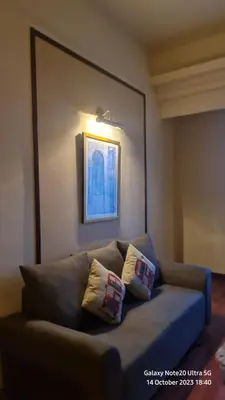 a couch in a living room with two pillows on it at Regal Servies Suites at Times Square KL in Kuala Lumpur