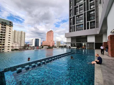 a man sitting in a swimming pool in a city at Chambers Suites KLCC Serviced Apartment in Kuala Lumpur