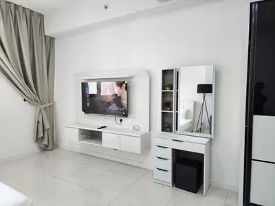 a white living room with a tv and a mirror at Chambers Suites KLCC Serviced Apartment in Kuala Lumpur