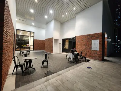 a person sitting at a table in a room with tables and chairs at Chambers Suites KLCC Serviced Apartment in Kuala Lumpur