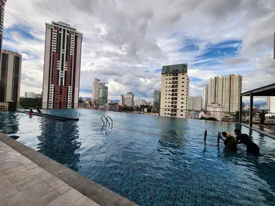 two people are in a swimming pool in a city at Chambers Suites KLCC Serviced Apartment in Kuala Lumpur
