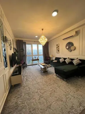 a living room with a couch and a chandelier at Elisa Sentrio Pandan Suites in Kuala Lumpur