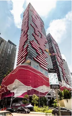 a tall red building with cars parked in front of it at FHS Homestay @ Arte Plus Jalan Ampang T3-33A-07 in Kuala Lumpur