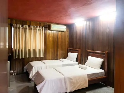 two beds in a room with wooden walls at Hotel O I.villa Inn in Kuala Lumpur