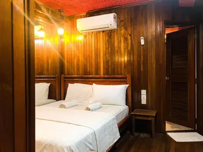 two beds in a small room with wooden walls at Hotel O I.villa Inn in Kuala Lumpur