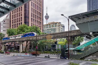 a train on a bridge in a city with buildings at Quill City Residences KLCC, Five Senses in Kuala Lumpur