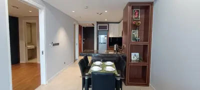 a dining room with a table and chairs and a kitchen at Anggun Residences KLCC by LuxLofts in Kuala Lumpur