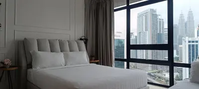 a bedroom with a white bed and a large window at Anggun Residences KLCC by LuxLofts in Kuala Lumpur