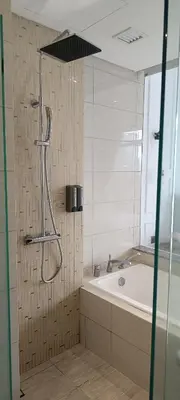 a bathroom with a shower and a bath tub at Anggun Residences KLCC by LuxLofts in Kuala Lumpur