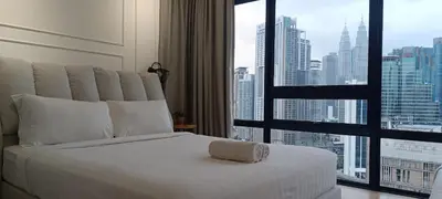 a white bed in a room with a large window at Anggun Residences KLCC by LuxLofts in Kuala Lumpur