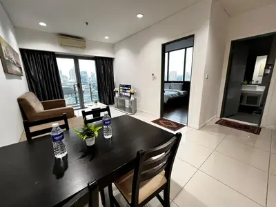 a kitchen and living room with a table and chairs at Summer Suites KLCC By Homestay in Kuala Lumpur
