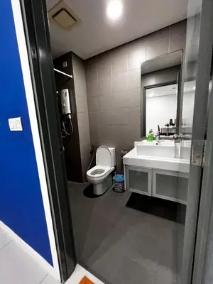 a bathroom with a toilet and a sink and a mirror at Summer Suites KLCC By Homestay in Kuala Lumpur