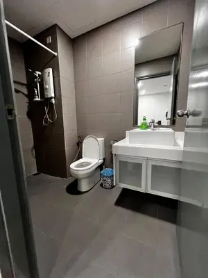a bathroom with a toilet and a sink and a mirror at Summer Suites KLCC By Homestay in Kuala Lumpur