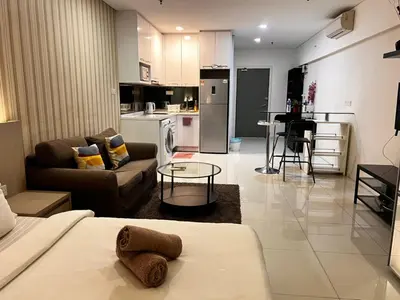 a living room with a couch and a table at Summer Suites KLCC By Homestay in Kuala Lumpur