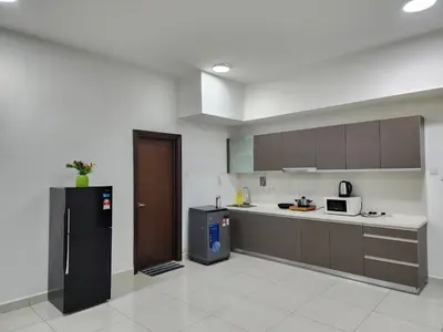 a kitchen with a black refrigerator and a stove at Regalia Comfort Suites KLCC SkyPool in Kuala Lumpur
