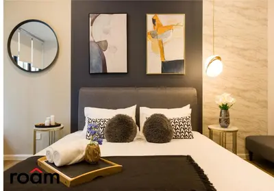 a bedroom with a bed with pillows and a mirror at Ceylonz Signature Suites, Bukit Bintang in Kuala Lumpur