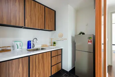 a kitchen with wooden cabinets and a refrigerator at UNA Signature Suites, Sunway KL in Kuala Lumpur
