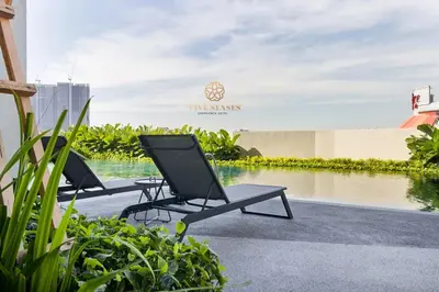 two chairs and a table next to a body of water at UNA Signature Suites, Sunway KL in Kuala Lumpur