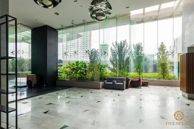 a lobby with a couch and a large window at Dua Sentral Signature Suites in Kuala Lumpur