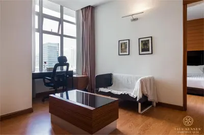 a bedroom with a bed and a desk and a window at Dua Sentral Signature Suites in Kuala Lumpur
