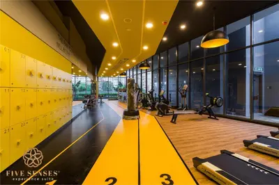 a gym with treadmills and a yellow ceiling at Neu Suites Signature Suites, KLCC in Kuala Lumpur