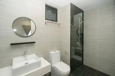 a bathroom with a toilet and a sink and a mirror at Cozy Skyline Retreat at Trion KL, Level 63 in Kuala Lumpur