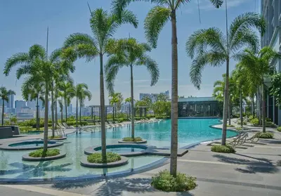 a pool with palm trees in a building at Cozy Skyline Retreat at Trion KL, Level 63 in Kuala Lumpur