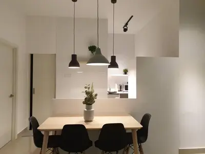 a dining room table with black chairs and pendant lights at Arte Plus Ampang KLCC City in Kuala Lumpur