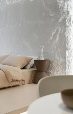 a white bedroom with a couch and a white wall at Chambers Suites KL by Wabi Wood's House in Kuala Lumpur
