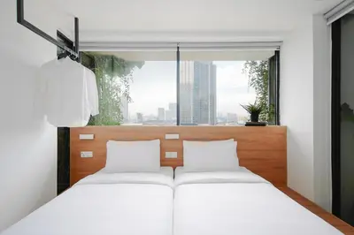 a bedroom with two beds and a large window at Lloyd's Inn Kuala Lumpur in Kuala Lumpur