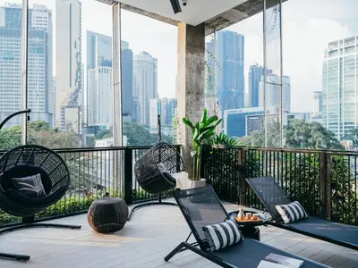 a balcony with chairs and a view of the city at Lloyd's Inn Kuala Lumpur in Kuala Lumpur