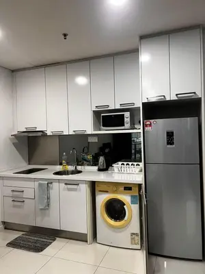 a kitchen with a stainless steel refrigerator and a washing machine at Summer Suits Klcc by KL Residence in Kuala Lumpur