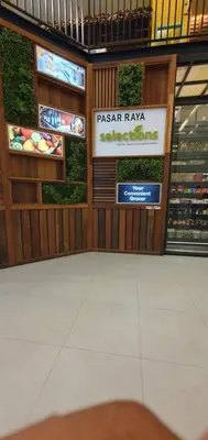 a person sitting in a grocery store with a sign on the wall at Summer Suits Klcc by KL Residence in Kuala Lumpur