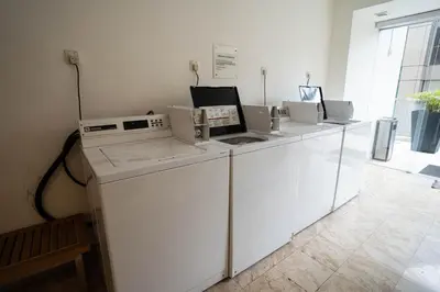 a row of white washing machines in a room at 6 PAX, Studio, 3mins to KLCC (3A01) in Kuala Lumpur