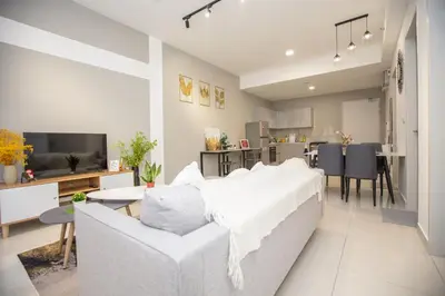 a living room with a white couch and a kitchen at Trion KL city centre near KLCC & TRX by MY TRIP & MY STAY in Kuala Lumpur