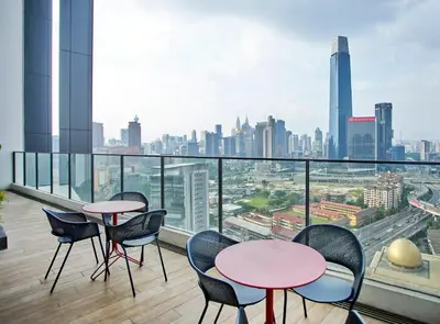 a balcony with tables and chairs and a city skyline at Continew Residence TRX KL in Kuala Lumpur