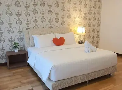 a bedroom with a white bed with a red heart pillow at Regalia Suites with Infinity Pool KLCC by Staycation Homes in Kuala Lumpur