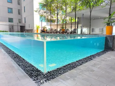 a swimming pool with blue water in a building at Mercu summer Suites by KL Residence in Kuala Lumpur