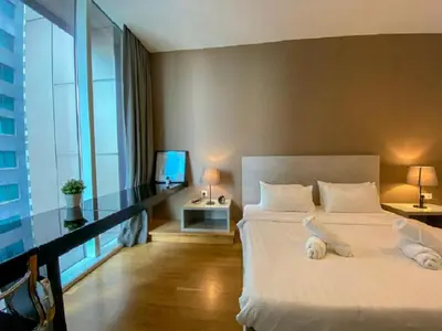a bedroom with a large white bed and a window at PLATINUM Suites KLCC By AR Hospitality in Kuala Lumpur
