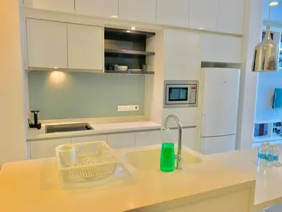 a kitchen with a sink and a white refrigerator at PLATINUM Suites KLCC By AR Hospitality in Kuala Lumpur