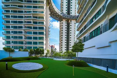 a golf course in a city with tall buildings at Datum Jelatek - KLCC Sky Ring Linked To LRT & Mall by AwNa in Kuala Lumpur
