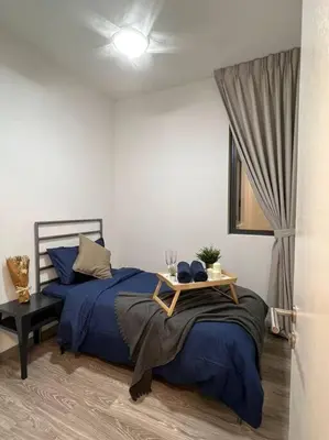 a bedroom with a blue bed and a table at Idyllic Cottage 3BR Desa Park City Mont Kiara in Kuala Lumpur