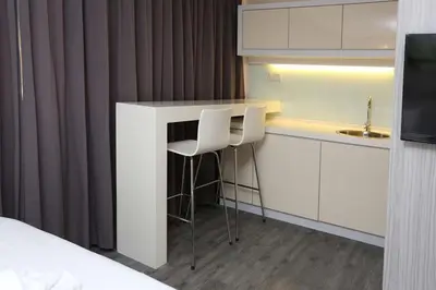 a white kitchen with a counter and a sink at Hotel Westree KL Sentral in Kuala Lumpur