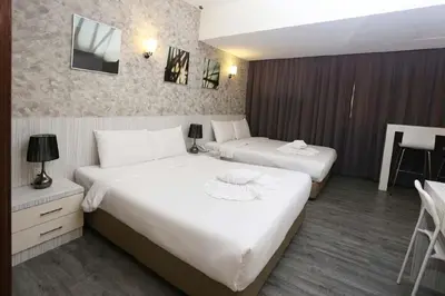 a hotel room with two beds and a table at Hotel Westree KL Sentral in Kuala Lumpur