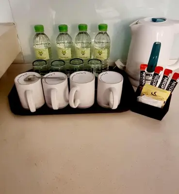 a group of coffee cups and wine bottles on a shelf at Hotel Westree KL Sentral in Kuala Lumpur