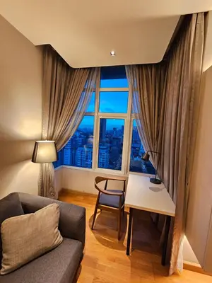 a living room with a couch and a desk and a window at Premier 2BR Suites, Dua Sentral in Kuala Lumpur