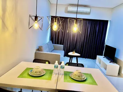 a living room with a table and a couch at Summer suites KLCC by cozy stay in Kuala Lumpur