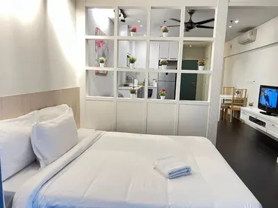 a white bedroom with a large bed and a television at Summer suites KLCC by cozy stay in Kuala Lumpur