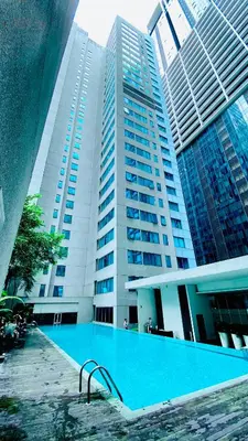 a large building with a swimming pool in front of it at Summer suites KLCC by cozy stay in Kuala Lumpur